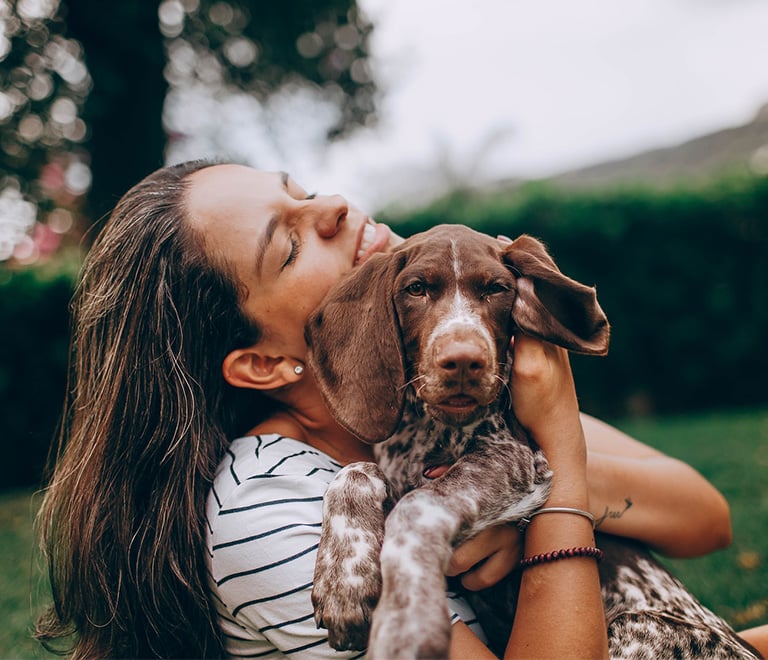 Femme qui donne un bisou à son chien.