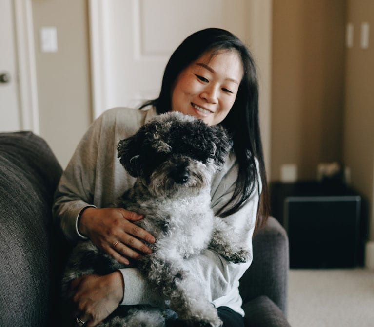 a child and a dog lying on a bed looking at the camera