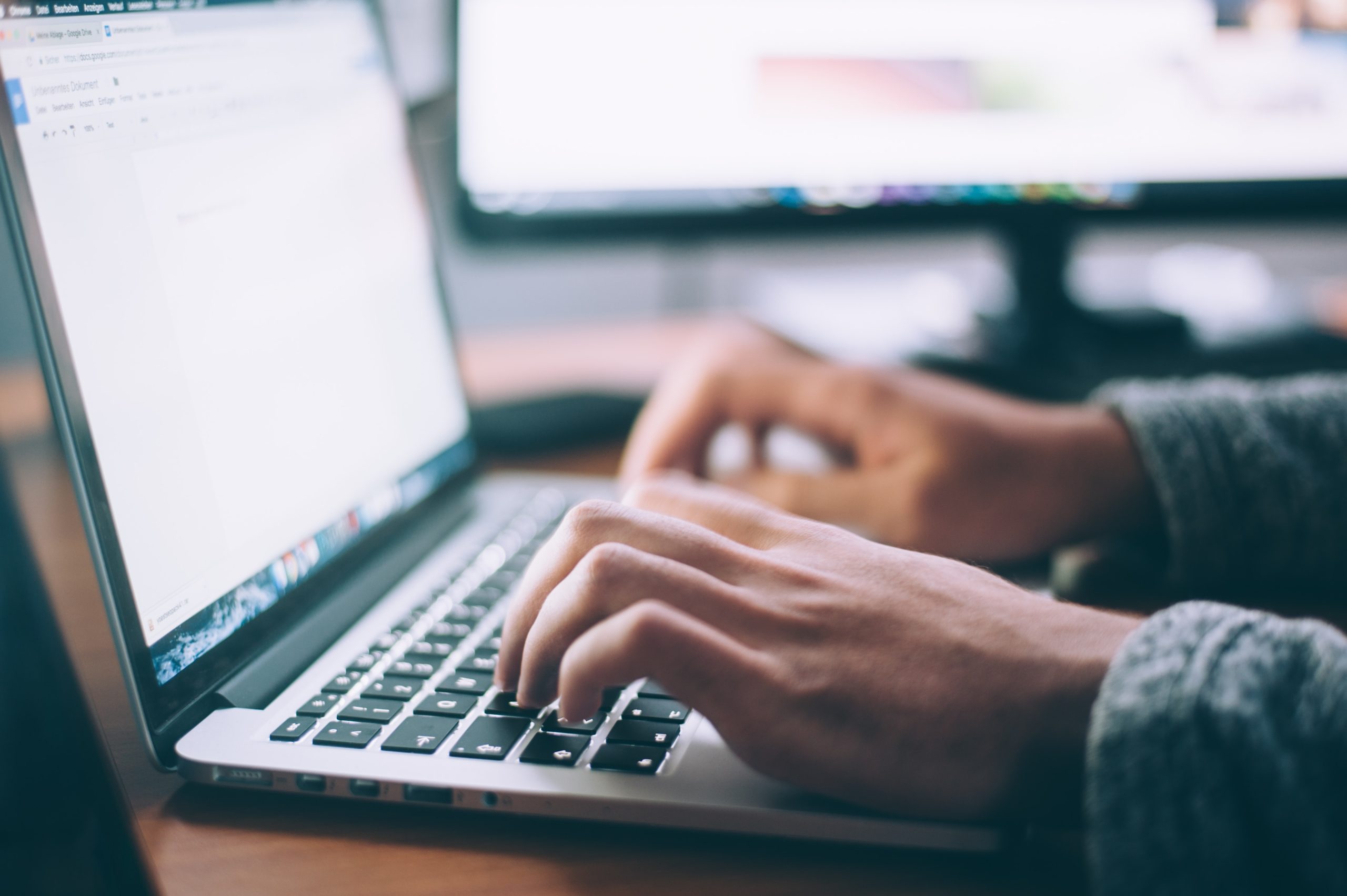 Main qui tape sur un clavier d'ordinateur portable - Analyste TI Proanima